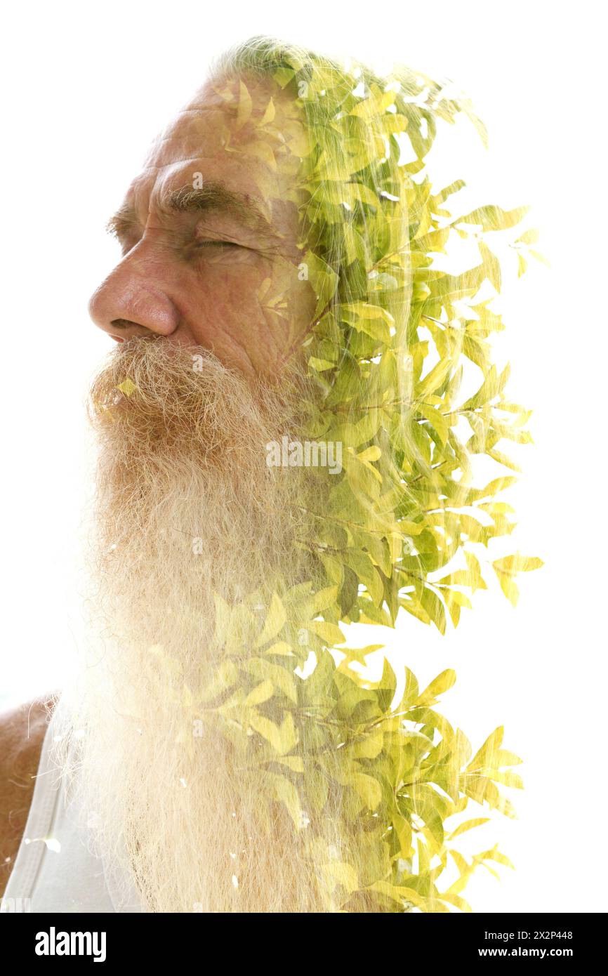 Un ritratto di un uomo barbuto che si fonde in foglie di albero verde in una doppia esposizione Foto Stock