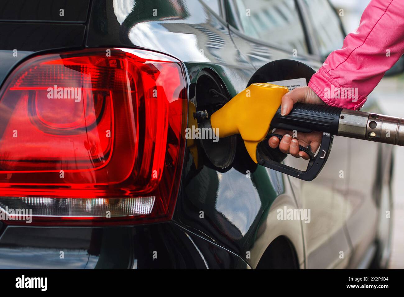 Woman Fillup Car al distributore di benzina, Black Car Foto Stock