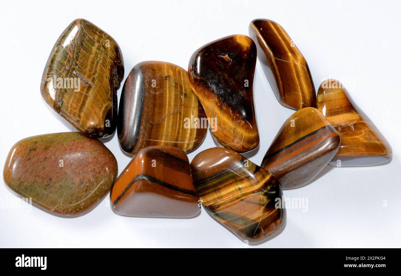 Una collezione di pietre preziose grezze dell'occhio di tigre, che mostrano la loro bellezza naturale, texture uniche e potente energia curativa nella loro forma lucida e lucida Foto Stock