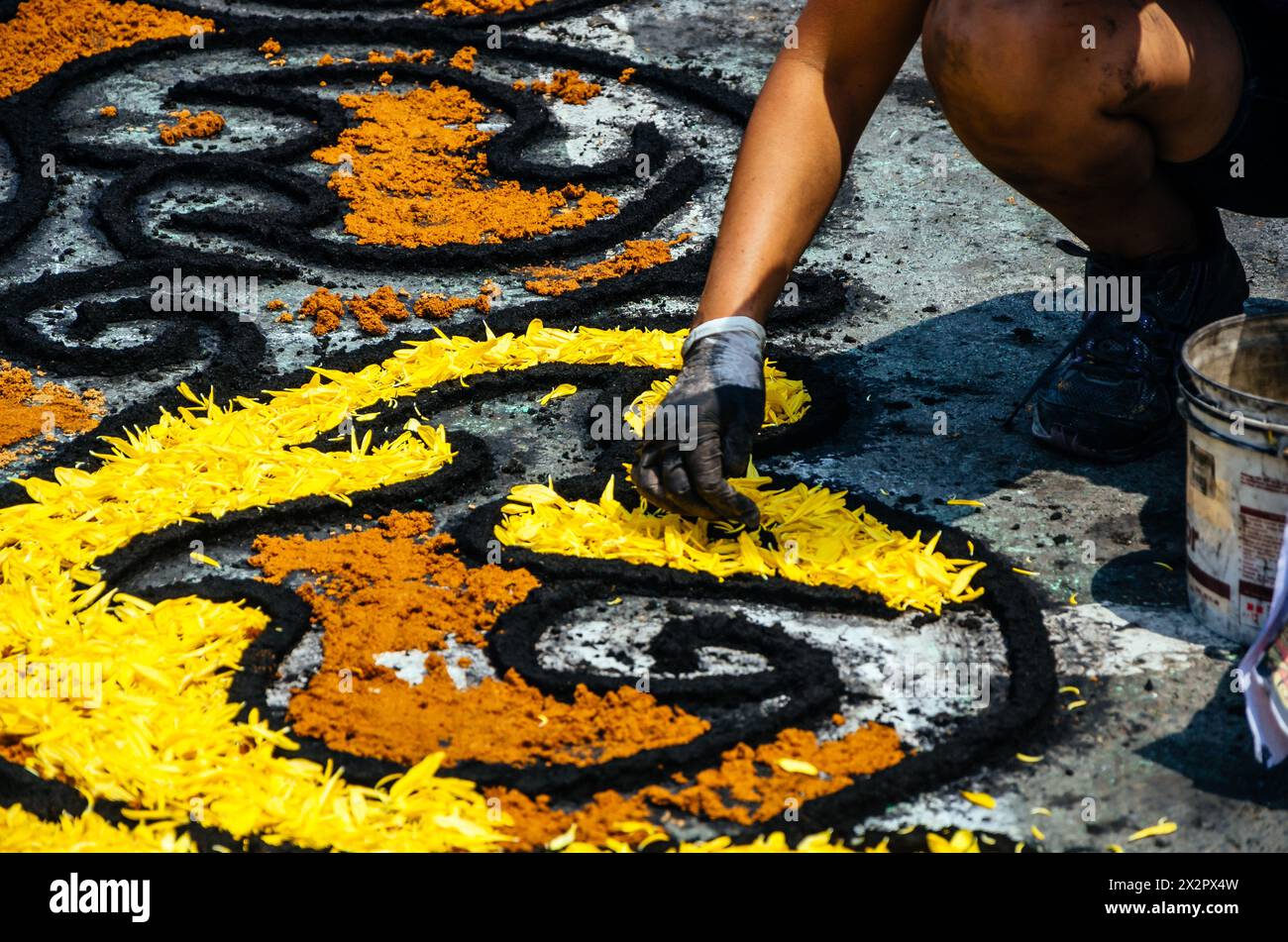 Primo piano di un abile artigiano che crea un intricato motivo floreale con petali gialli per un festival di Pasqua a Lima - Perù Foto Stock