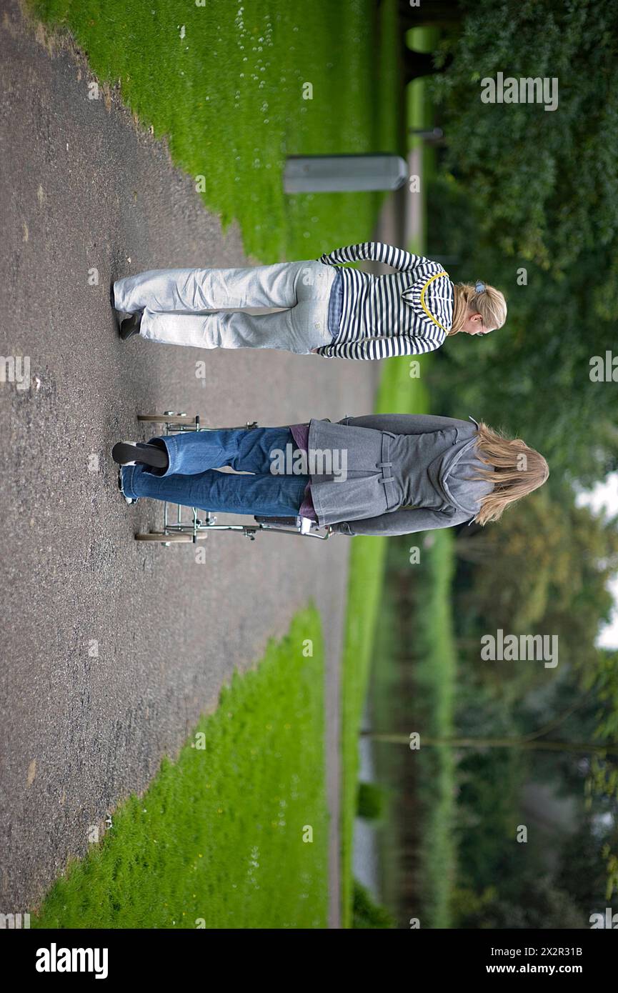 Due donne e un bambino due donne e un bambino all'interno di un puscart che parla e cammina alla Foresta di Kralingen durante un pomeriggio estivo. Rotterdam, Paesi Bassi. Rotterdam Vroesenpark Zuid-Holland Nederland Copyright: XGuidoxKoppesxPhotox Foto Stock