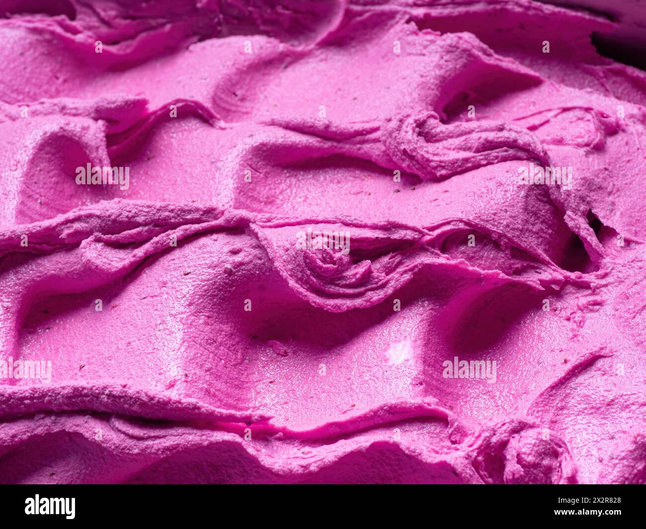 Gelato al lampone congelato - dettaglio completo. Primo piano di una superficie rosa di gelato. Foto Stock