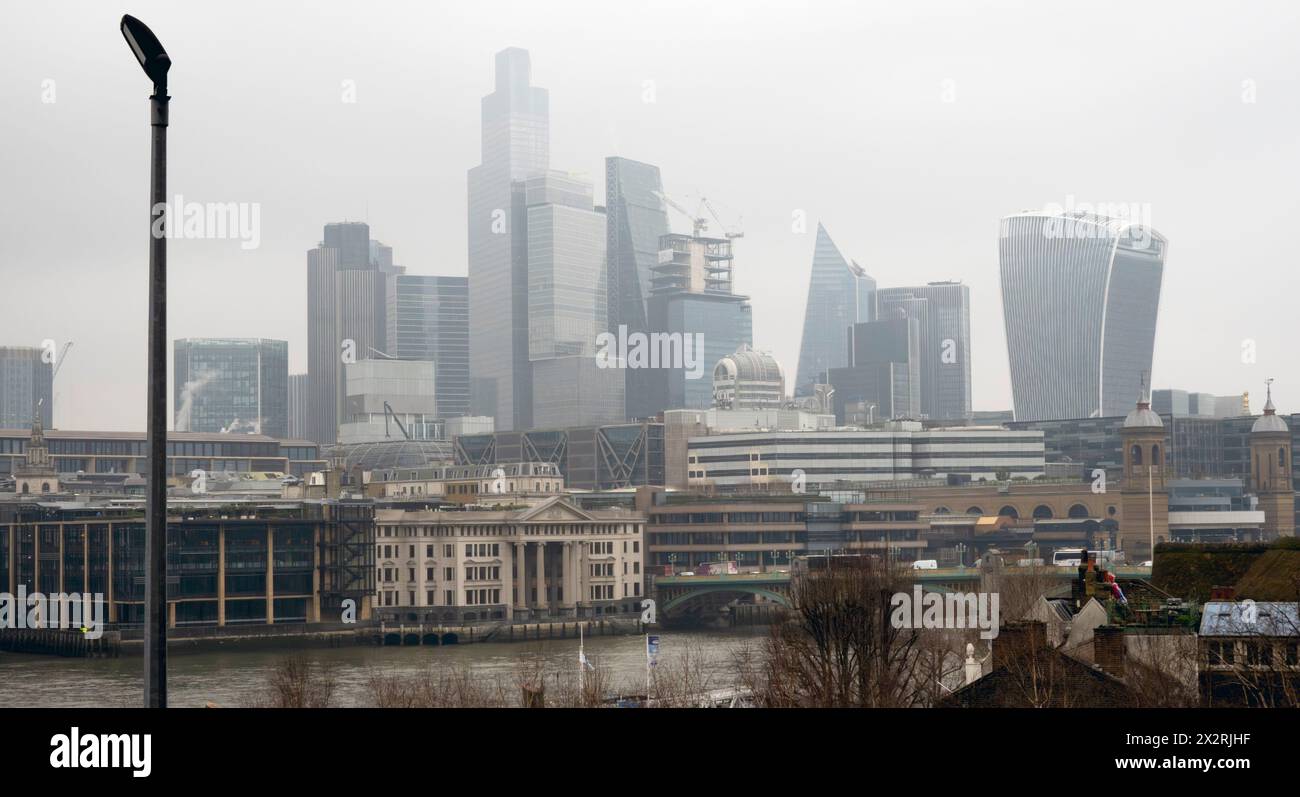 Lo skyline nebuloso di Londra si vede dal Tamigi in inverno Foto Stock
