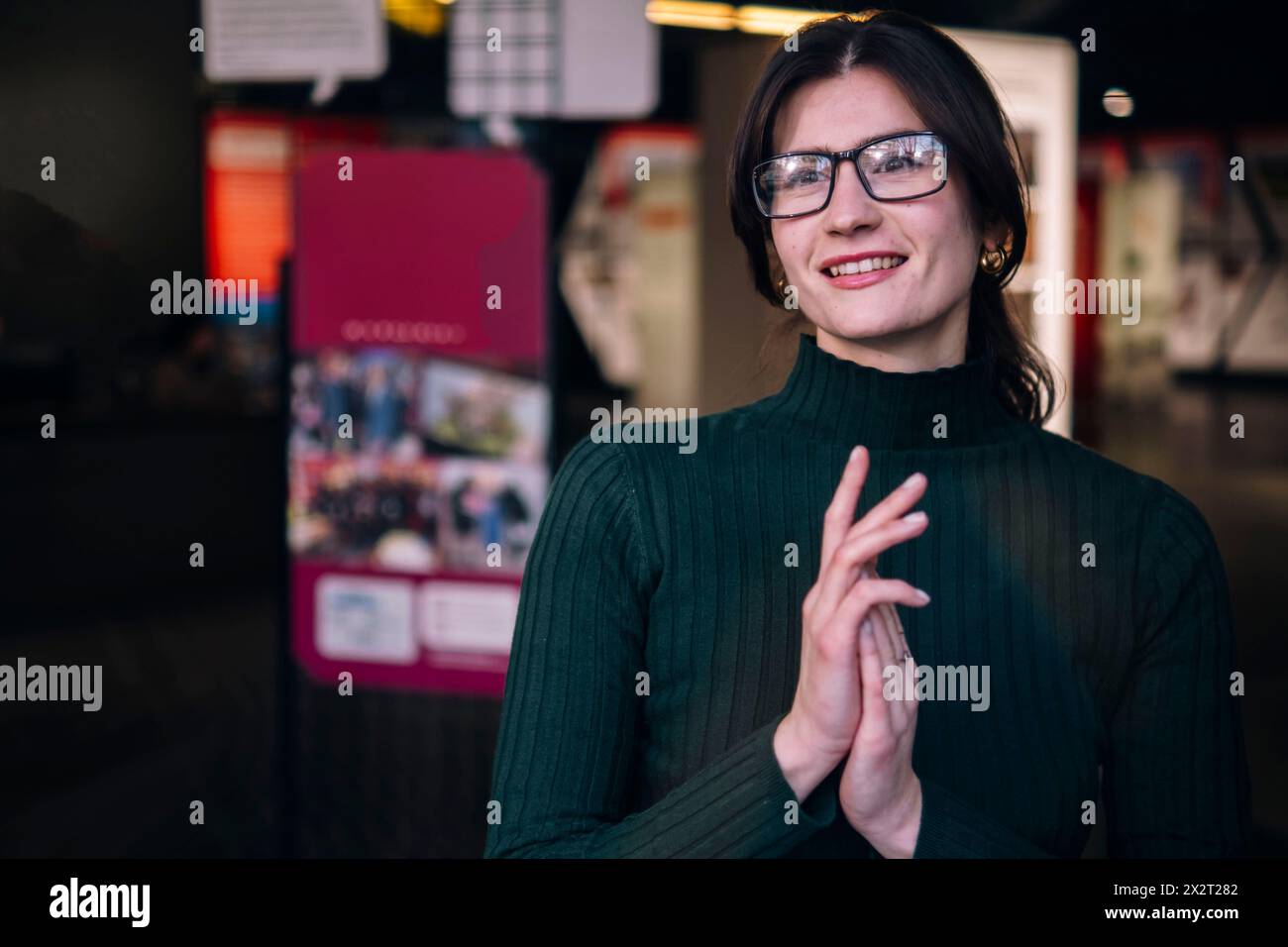Donna d'affari sorridente che indossa occhiali da vista al bar Foto Stock