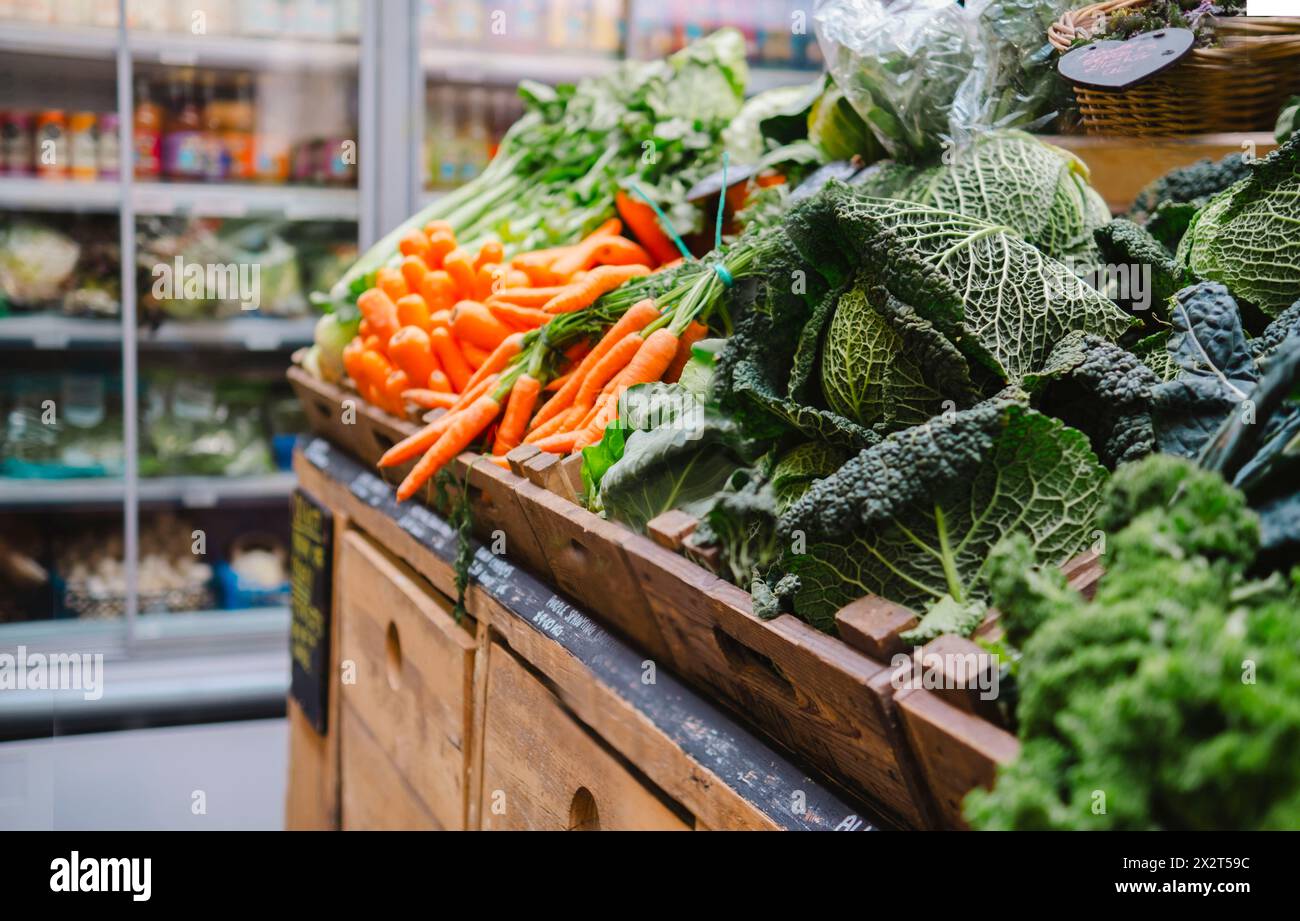 Verdure a foglia verde fresche in casse di legno al supermercato Foto Stock