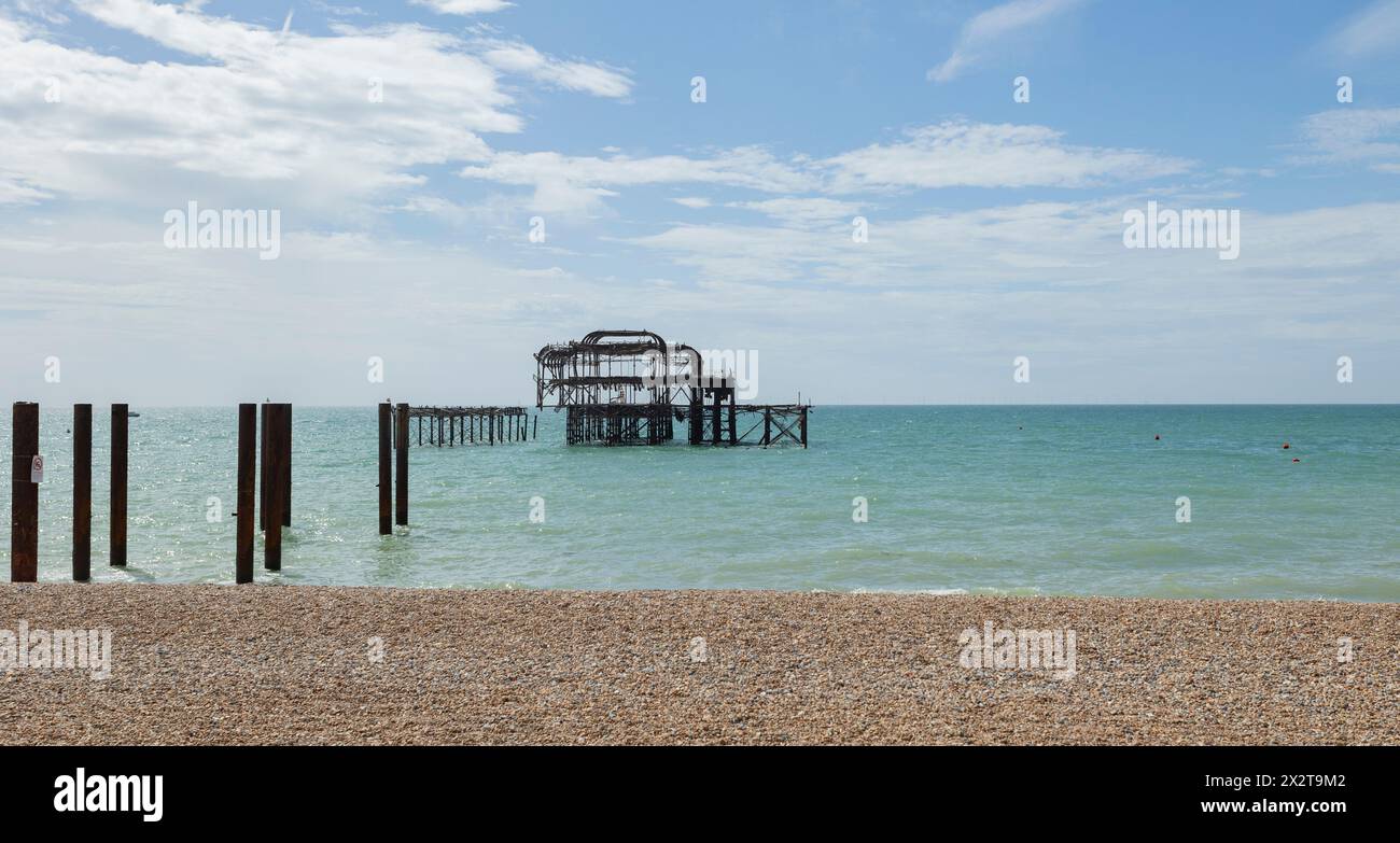 Brighton, regno unito, 23, agosto 2022 il molo ovest rovine della spiaggia di ciottoli di Brighton, cielo e mare azzurri Foto Stock