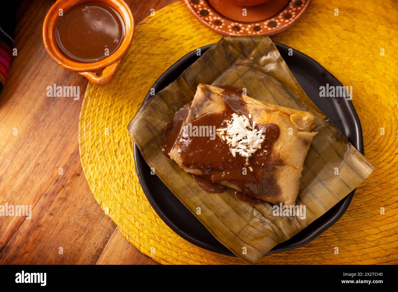 Oaxacan Tamale. Piatto preispanico tipico del Messico e di alcuni paesi dell'America Latina. Impasto di mais avvolto in foglie di banana. I tamales sono cotti al vapore. Foto Stock