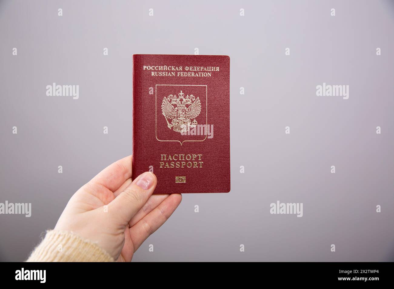 Primo piano di una mano femminile con passaporto russo Foto Stock