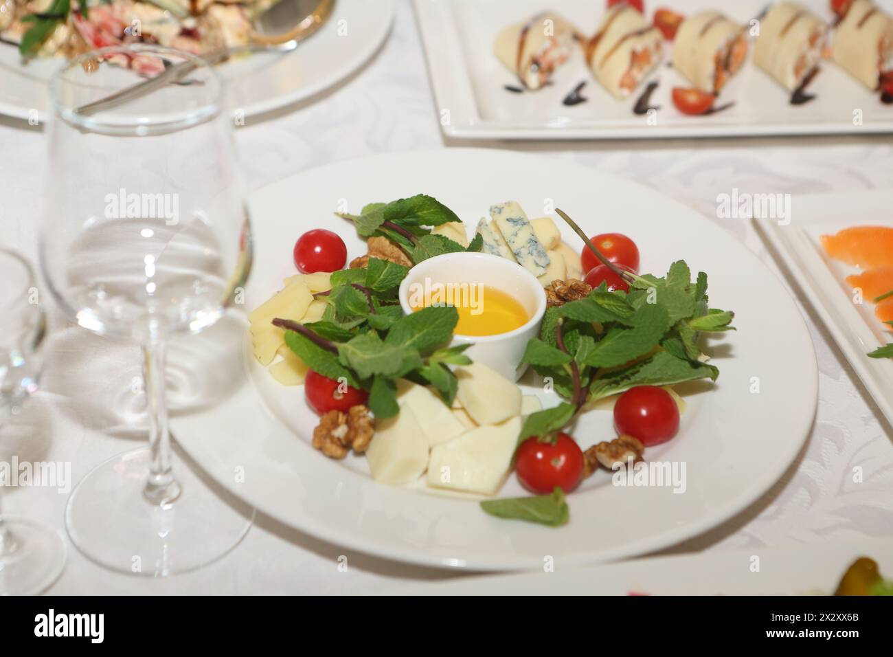 Vassoio di formaggi con miele su un piatto bianco Foto Stock