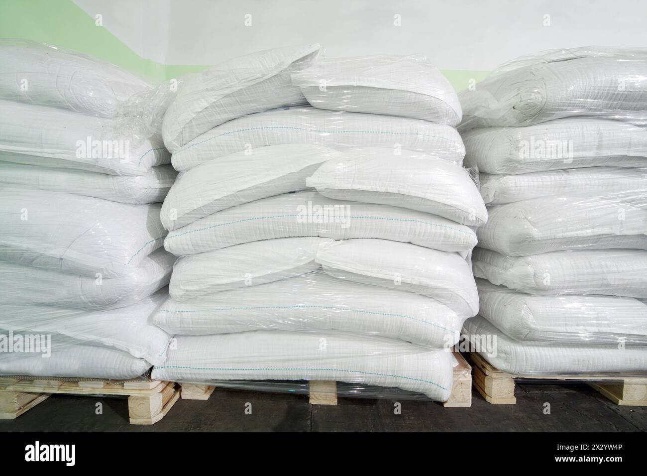 Tre pile di grandi sacchi bianchi in un grande magazzino in una fabbrica moderna. Foto Stock