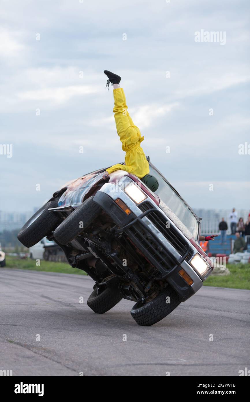 MOSCA - agosto 25: Stuntman si erge a testa in giù su un'auto che viaggia su due ruote durante il Festival dell'arte e del cinema stunt Prometheus a Tushino il 25 agosto 20 Foto Stock