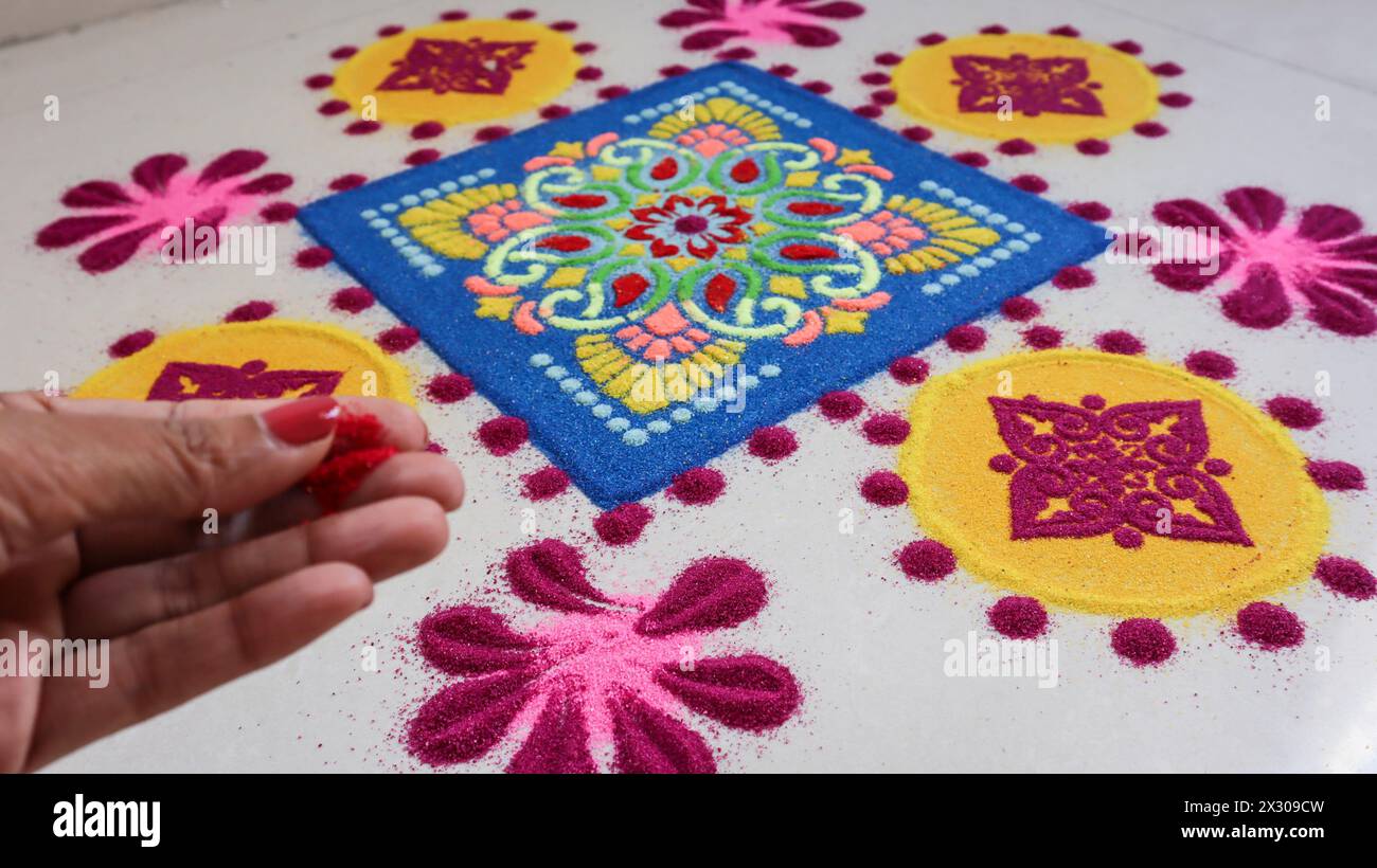 Donna che crea un bellissimo design Rangoli. Produzione Rangoli Foto Stock