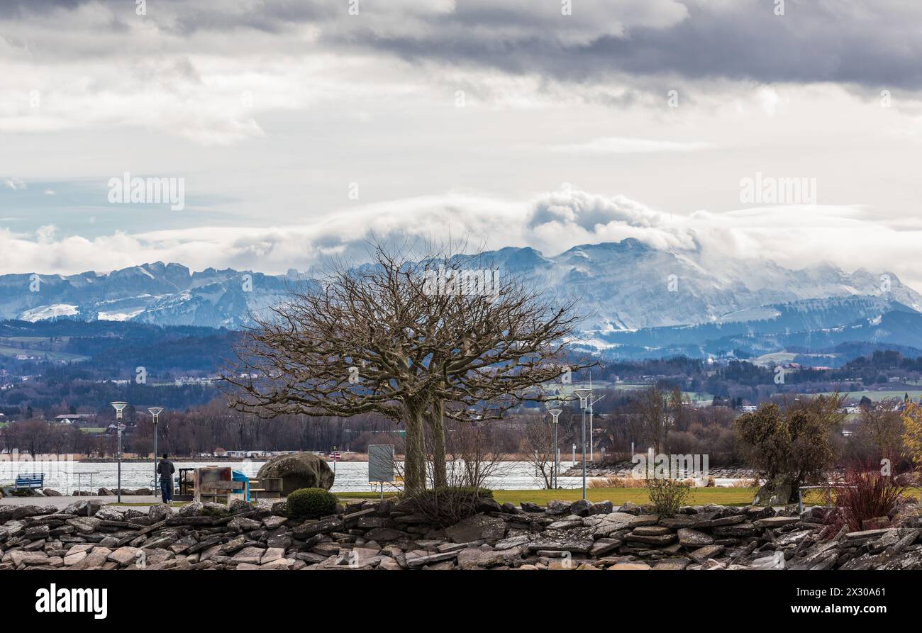 Romanshorn, Schweiz - 20. Febbraio 2022: A Richtung Schweizer Alpen sieht die Stimmung stürmisch aus. Dicke, graue Wolken ziehen Richtung Alpen. Foto Stock