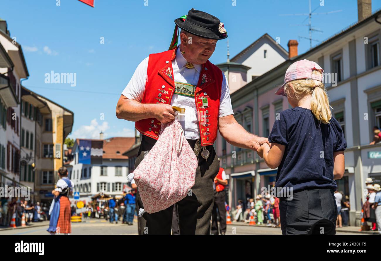 Ein Mann in einer Appenzeller Tracht gibt einem jungen Mädchen ein Gebäck. (Bad Zurzach, Schweiz, 12.06.2022) Foto Stock
