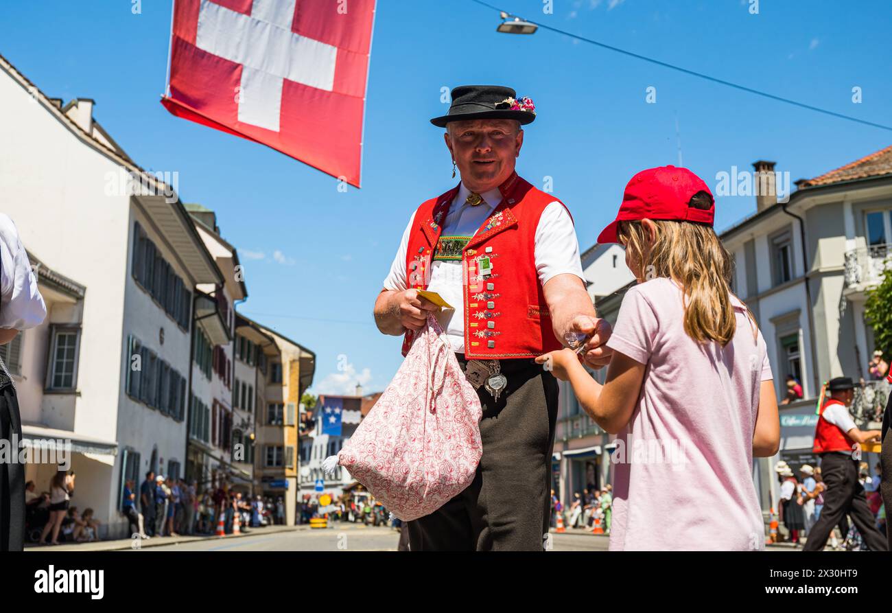 Ein Mann in einer Appenzeller Tracht gibt einem jungen Mädchen ein Gebäck. (Bad Zurzach, Schweiz, 12.06.2022) Foto Stock