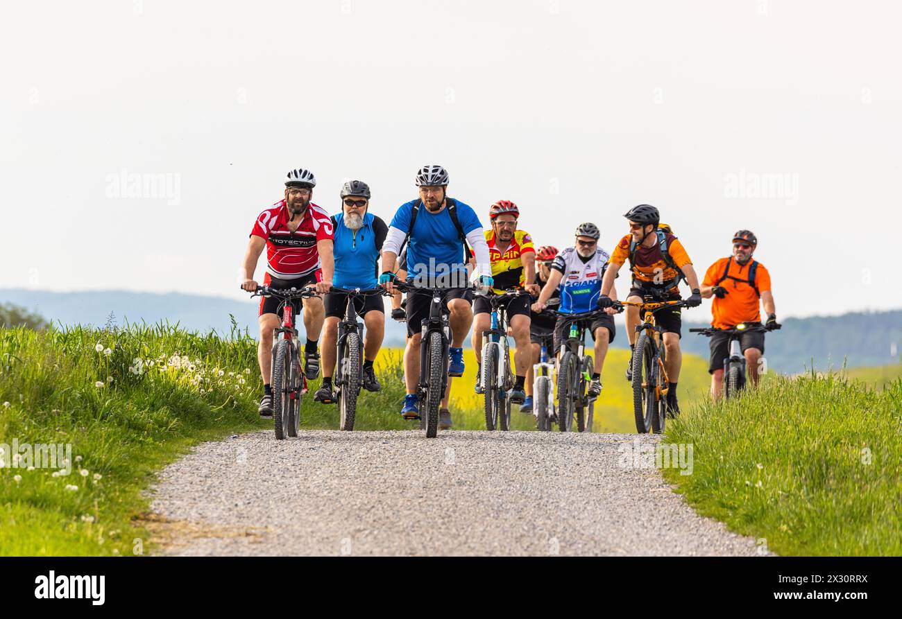 Eine Gruppe älterer Männer fährt mit ihren Mountainbikes auf einem Feldweg. (Oberglatt, Schweiz, 10.05.2022) Foto Stock