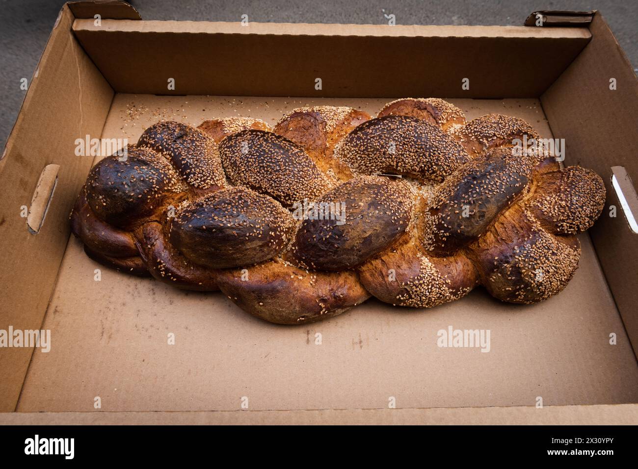 Grande pagnotta di Challah appena sfornata, intrecciata o pane all'uovo in vendita in una panetteria di Gerusalemme alla vigilia del sabato ebraico. Foto Stock