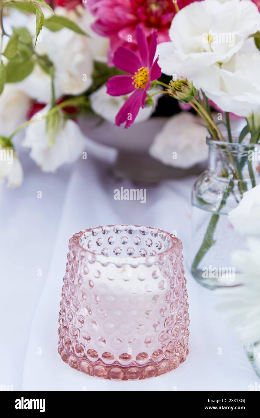 Candela morbida e bouquet di fiori. Per articoli e un'atmosfera accogliente e invitante. Foto Stock