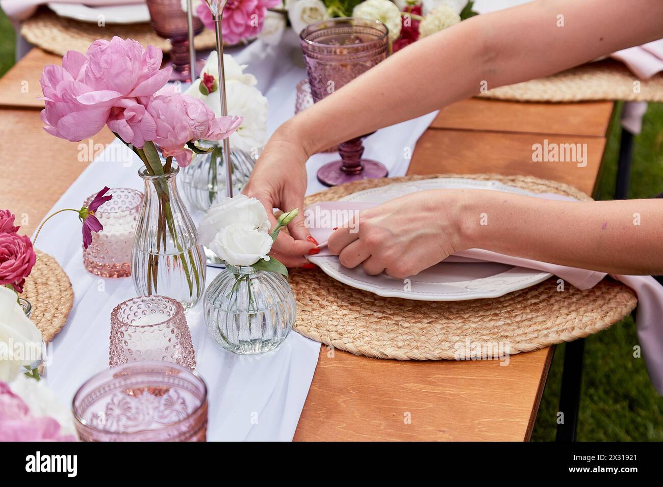 Elegante tavolo all'aperto con peonie rosa. Temi per ricevimenti nuziali ed eventi. Foto Stock