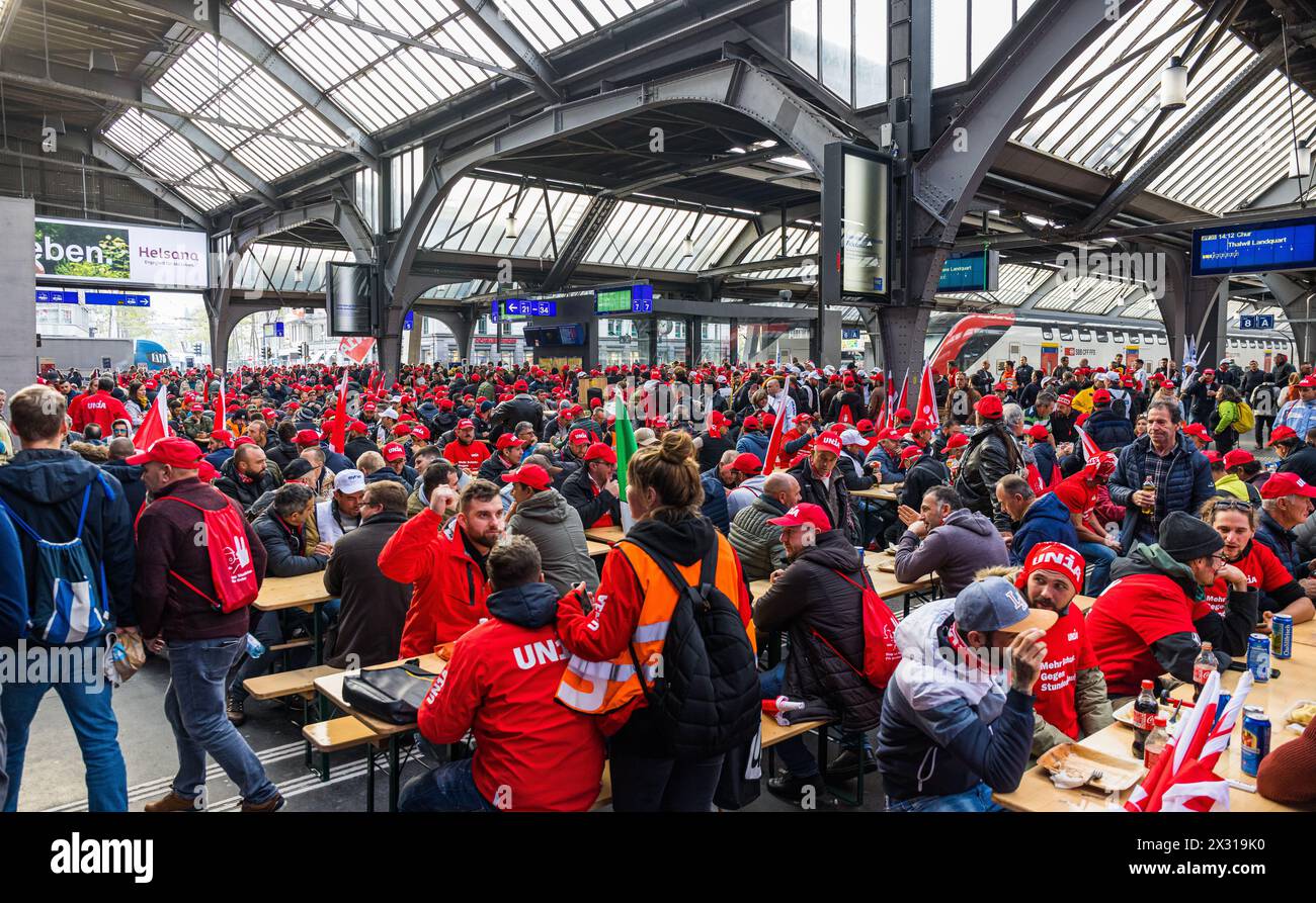 Die demonstrierenden Bauarbeiter haben in der Halle des Zürcher Hauptbahnhof kurzer Hand Bänke und Tische aufstellt. Die unbewilligte Aktion wurde von Foto Stock