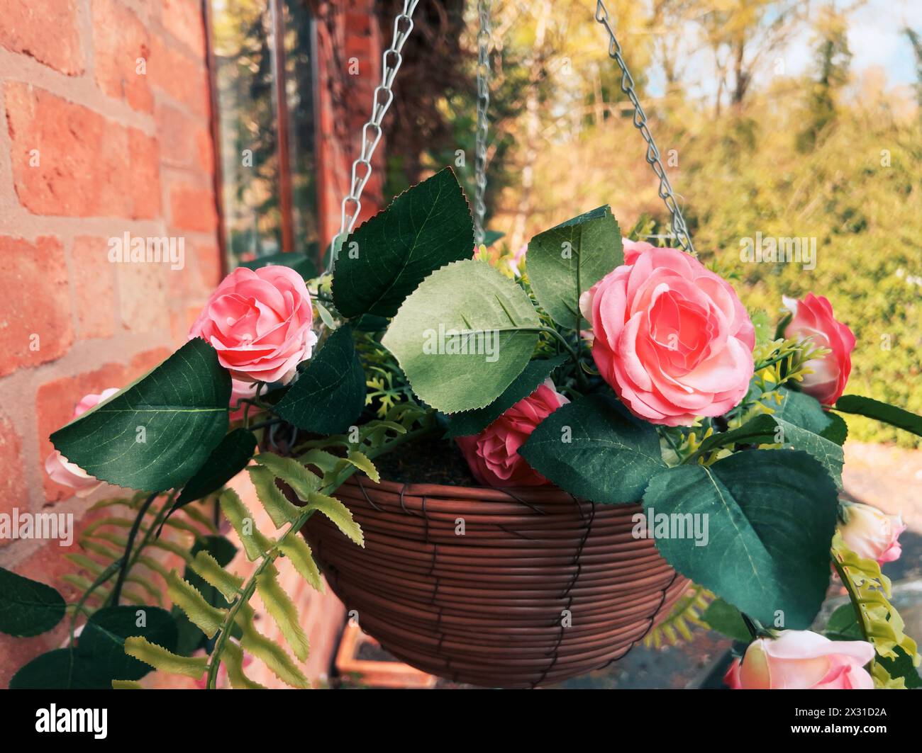 cestello sospeso pieno di fiori di plastica Foto Stock