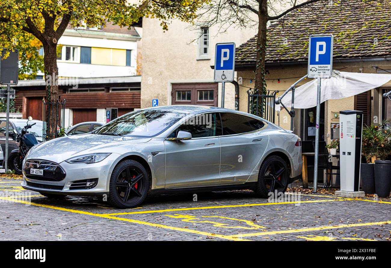 Ein Tesla Model S steht auf einem Parkplatz und ist an einer Ladestation angeschlossen. (Sciaffusa, Svizzera, 06.11.2022) Foto Stock
