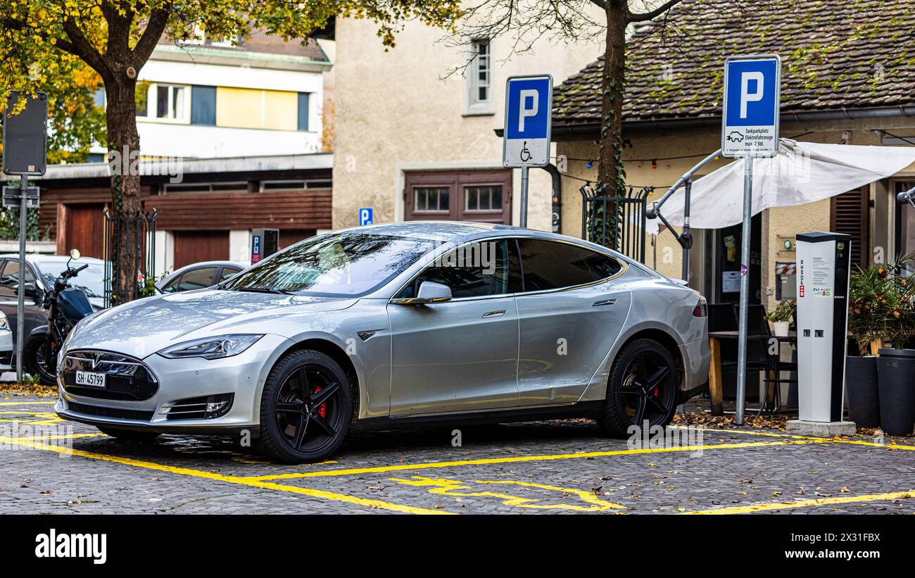 Ein Tesla Model S steht auf einem Parkplatz und ist an einer Ladestation angeschlossen. (Sciaffusa, Svizzera, 06.11.2022) Foto Stock