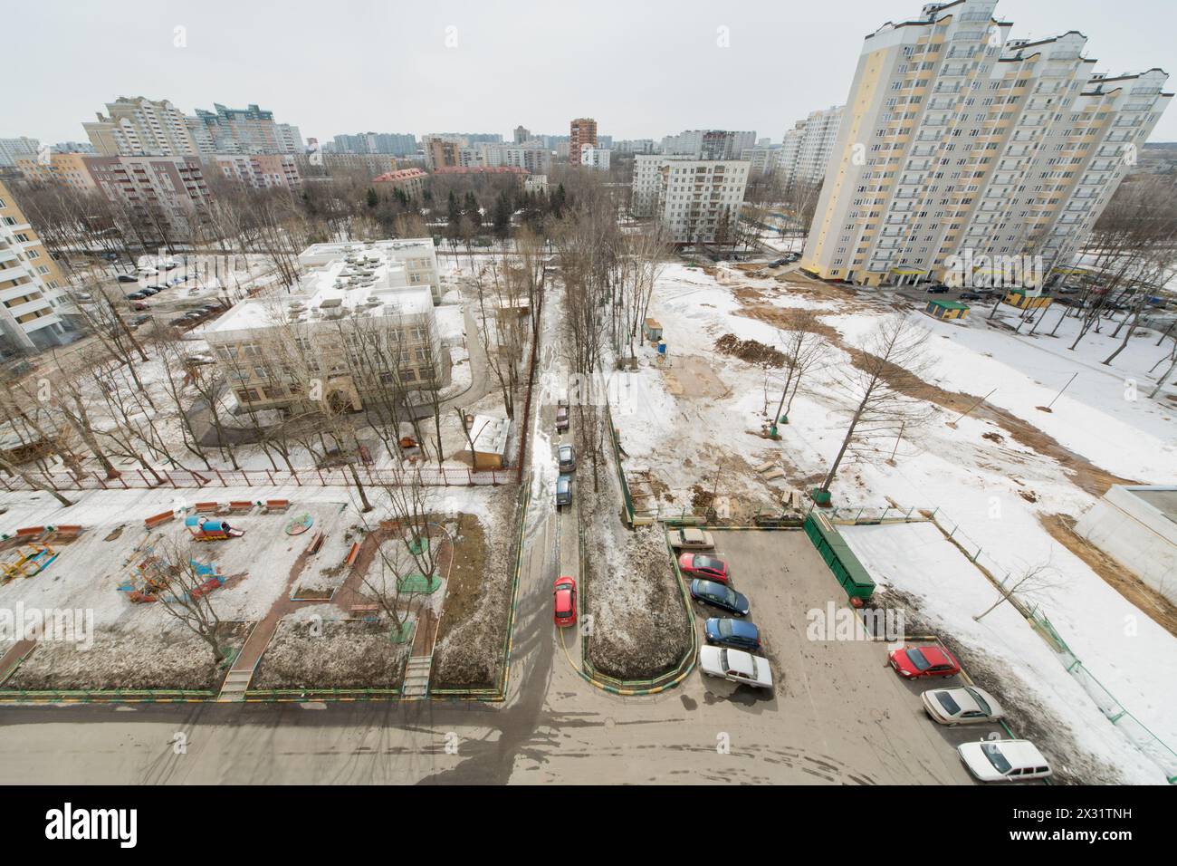Vista dall'alto del cortile con auto, case e parco giochi per bambini Foto Stock