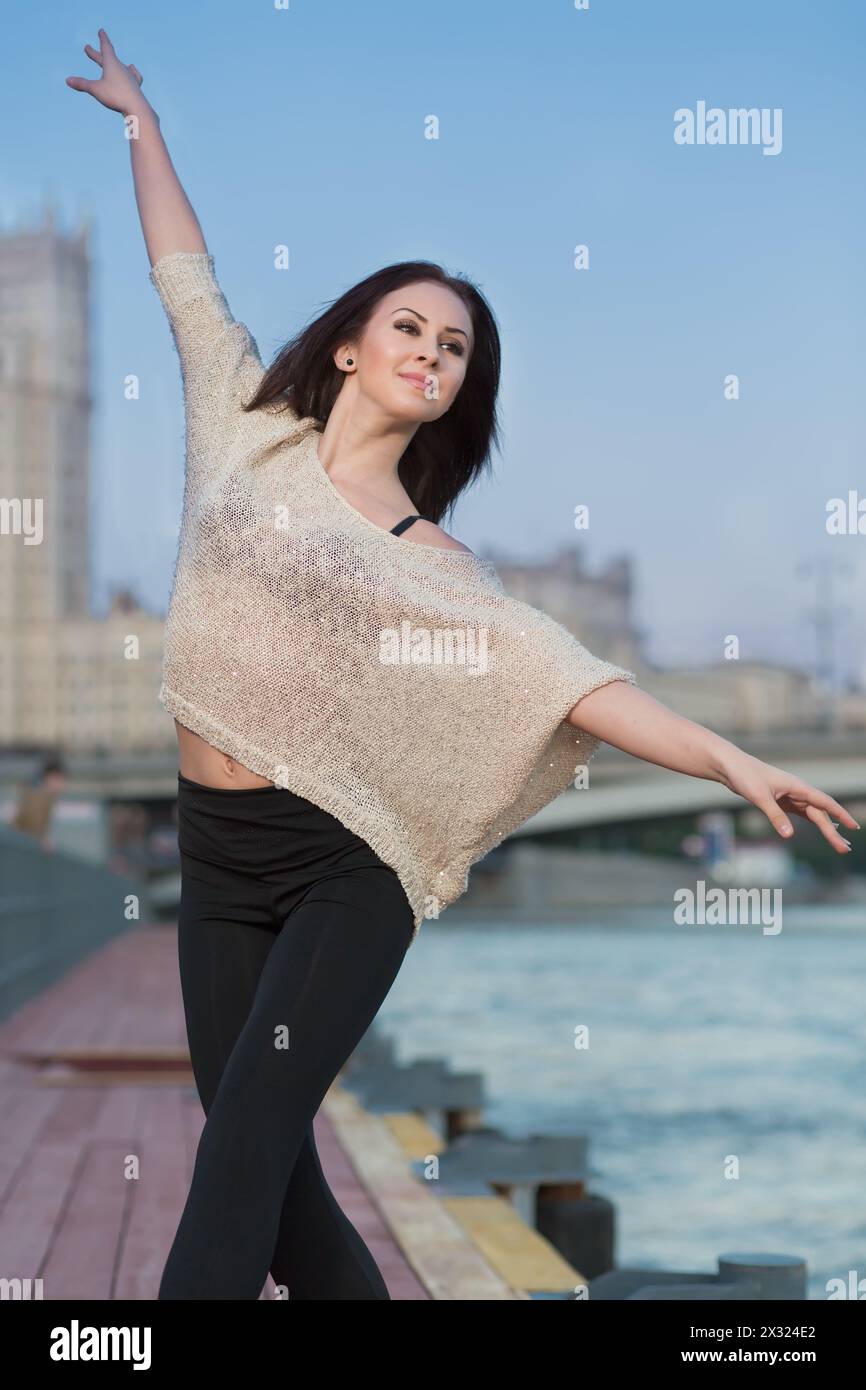 Una giovane donna è in piedi in una posizione di balletto sul lungomare Foto Stock