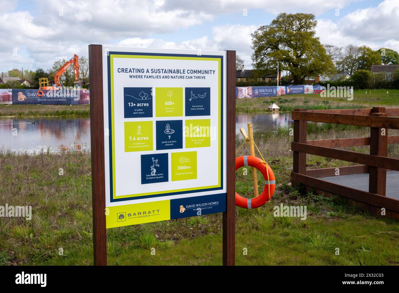 Un cartello accanto a un lago artificiale su un cantiere edile che dice che lo sviluppatore sta cercando di creare una comunità sostenibile. Foto Stock