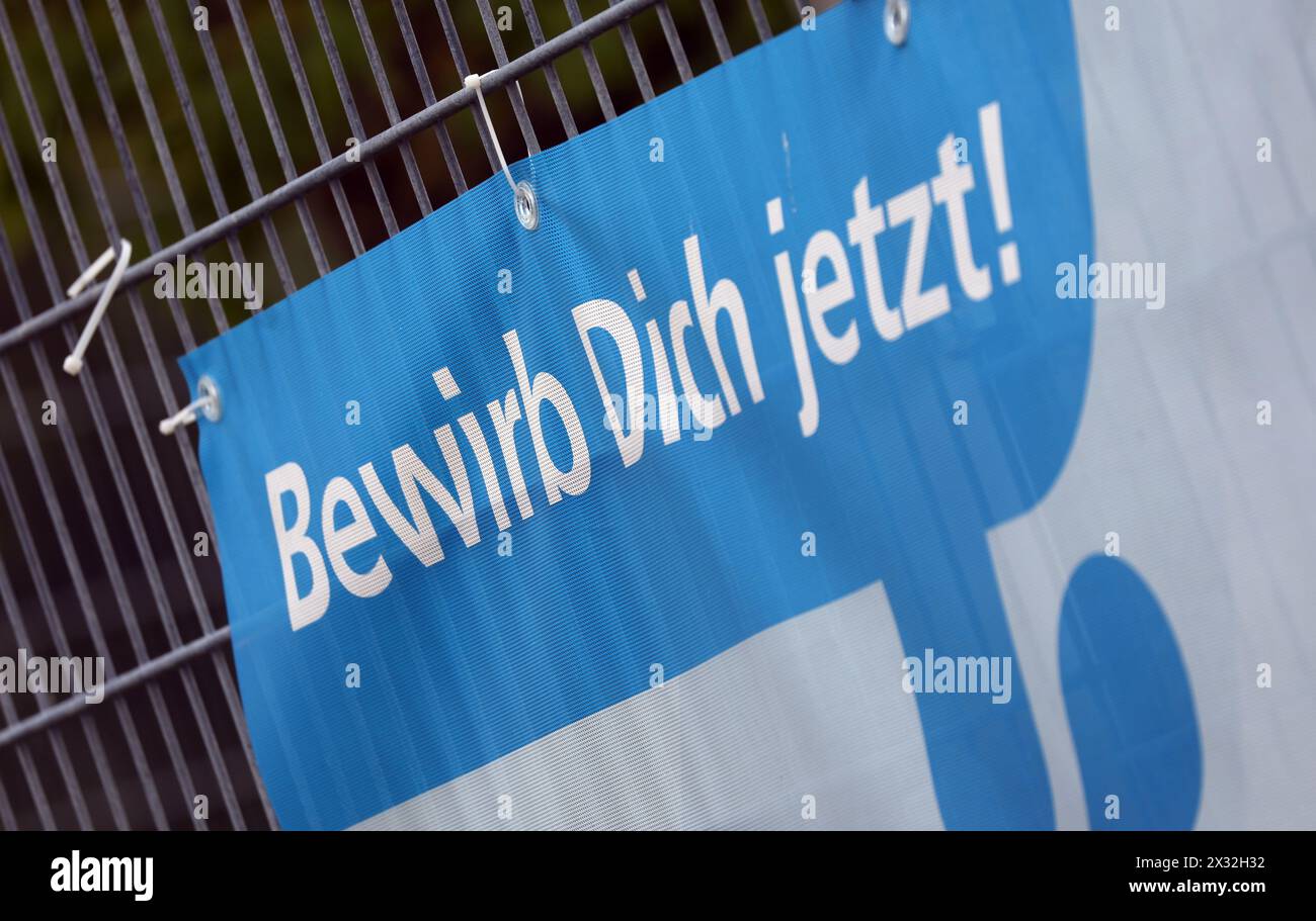 Mindelheim, Germania. 24 aprile 2024. "Iscriviti ora" può essere letto su un banner sulla recinzione di un'azienda che pubblicizza i tirocinanti nei mestieri specializzati. Crediti: Karl-Josef Hildenbrand/dpa/Alamy Live News Foto Stock