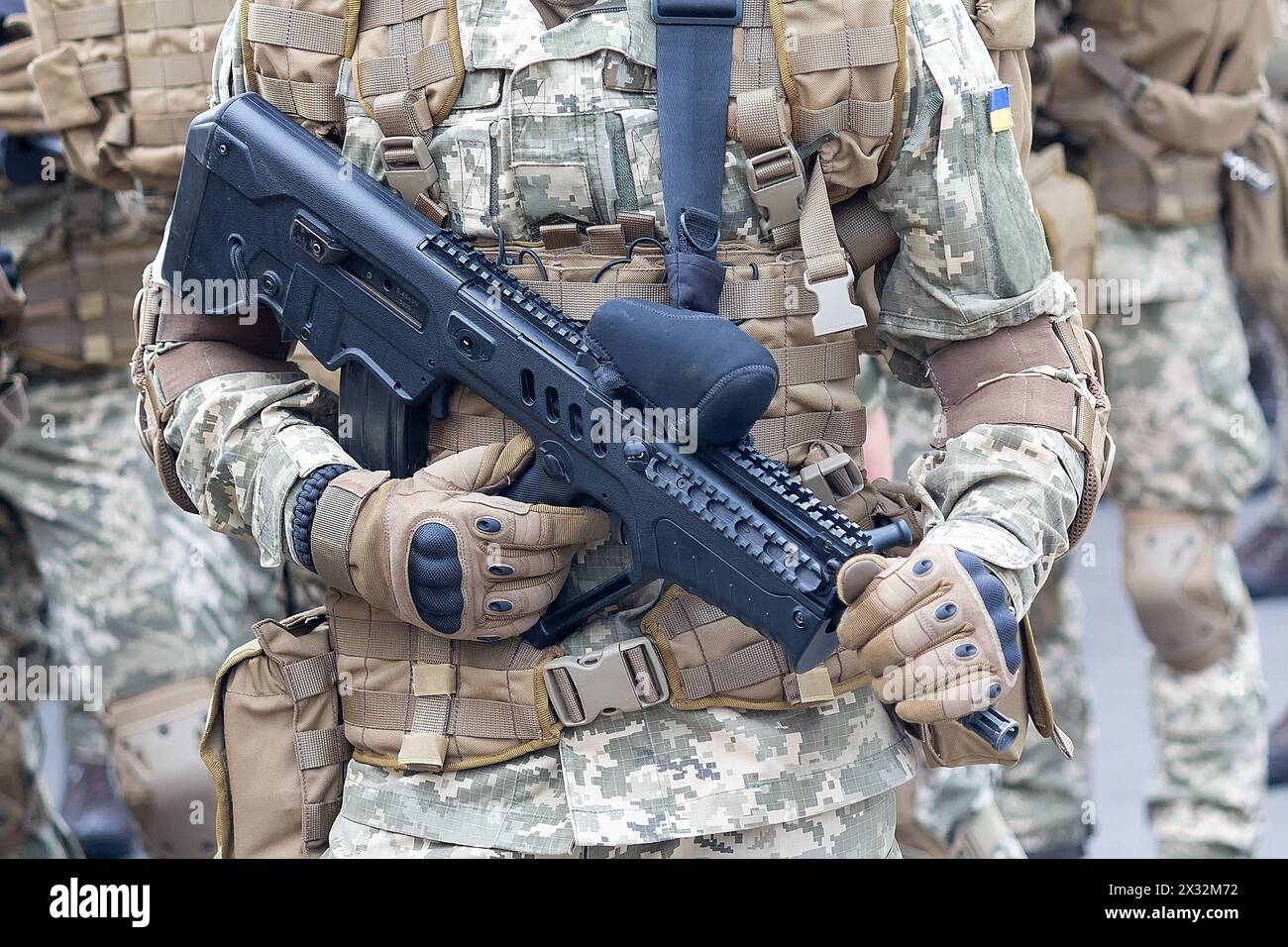 Un militare in uniforme mimetica con un fucile automatico e l'insegna dell'esercito ucraino Foto Stock