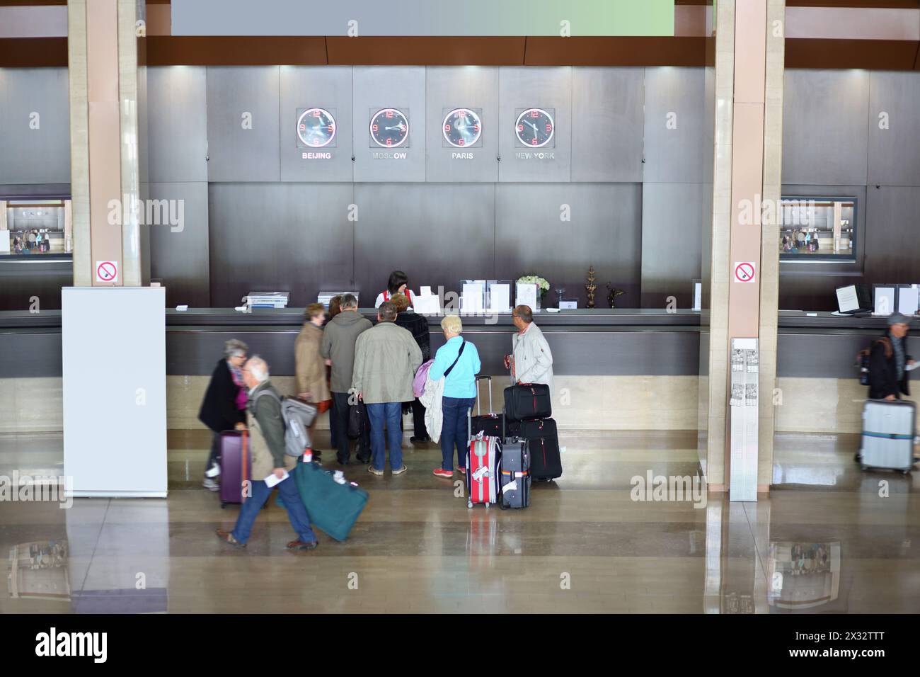 Vista dall'alto delle persone che si trovano vicino al banco di registrazione dell'hotel moderno Foto Stock