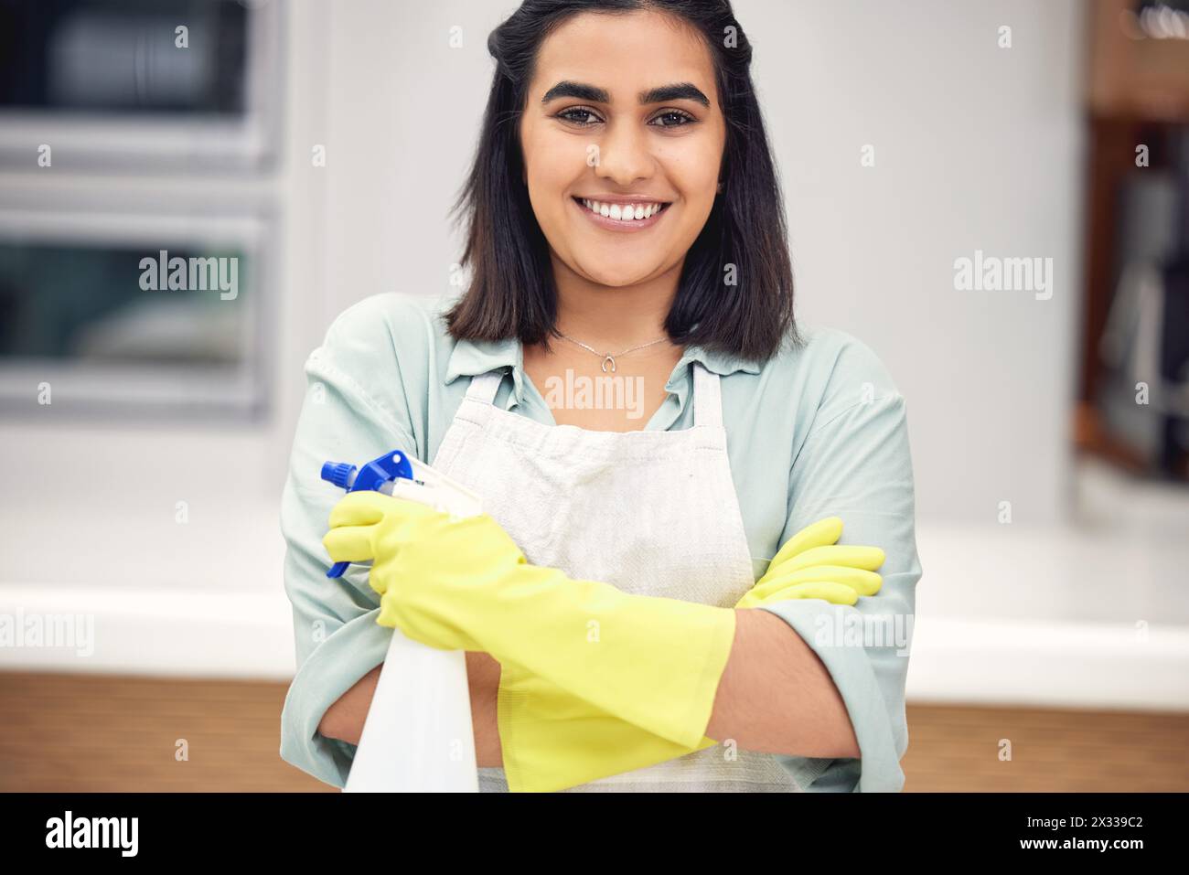 Pulizia, ritratti e sorrisi con i guanti o sicurezza in casa per la pulizia, la pulizia e lo sporco sui mobili. Donna indiana, felice e con le pulizie Foto Stock