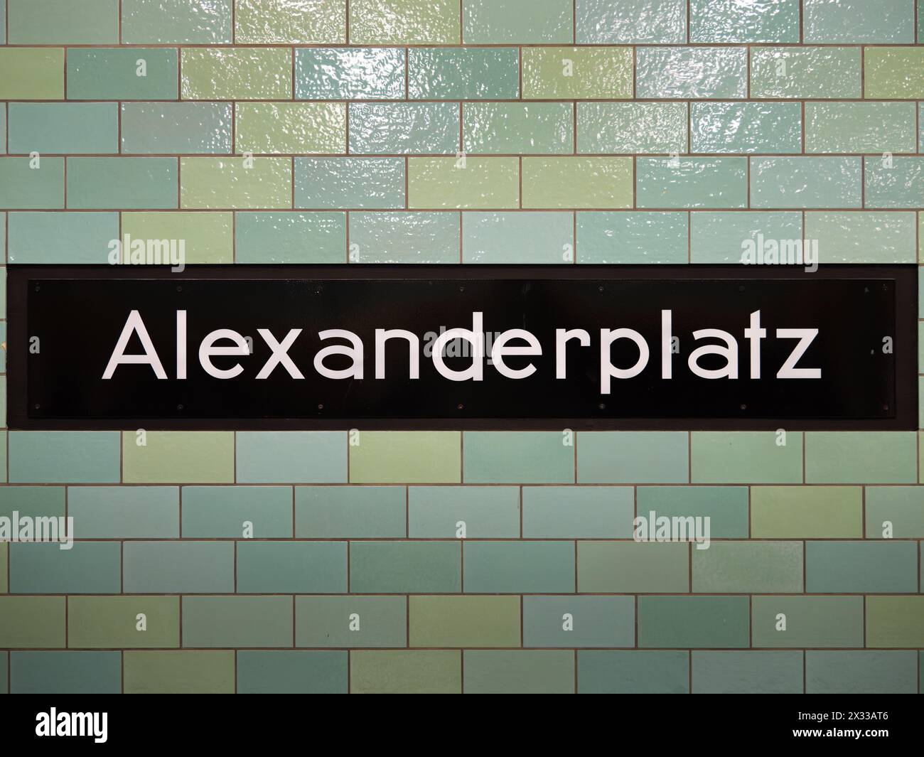 Segnale della stazione Alexanderplatz a Berlino. La segnaletica per la posizione dei mezzi pubblici fa parte della metropolitana. Il muro piastrellato è in verde blu. Foto Stock