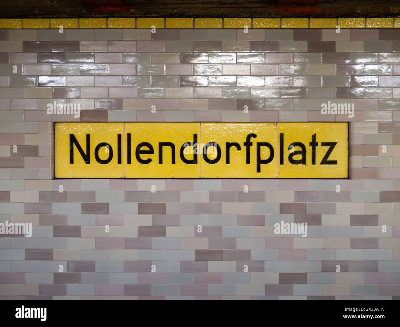 Cartello della stazione di Nollendorfplatz a Berlino. La segnaletica per la posizione dei mezzi pubblici fa parte della metropolitana. Il muro è piastrellato e vecchio. Foto Stock