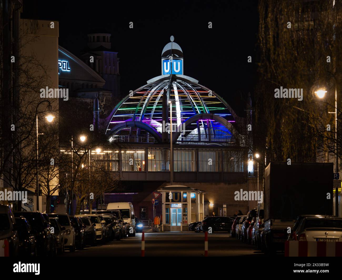 Edificio Nollendorfplatz della U-Bahn (sotterraneo) di notte illuminato da vivaci luci al neon nei colori dell'arcobaleno. Esterno della casa. Foto Stock