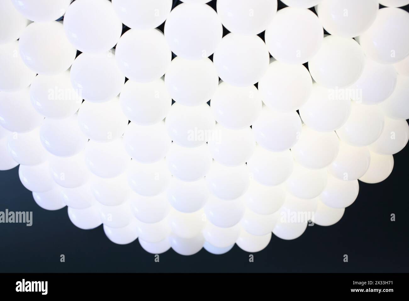 Bellissimo lampadario composto da una pluralità di sfere di vetro bianco in uno stile moderno Foto Stock