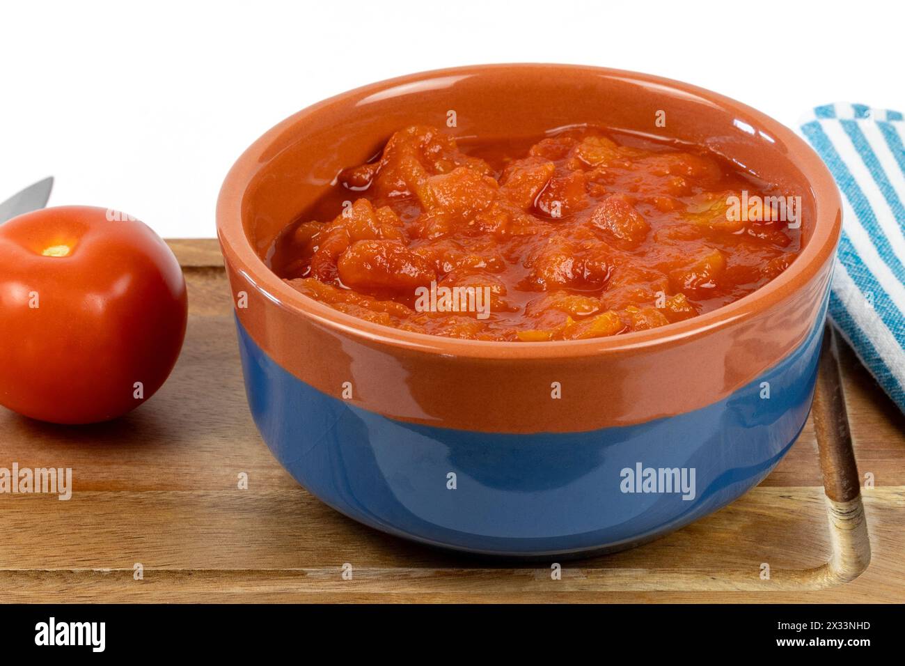 recipiente di pomodori tritati, da vicino, su un tagliere Foto Stock