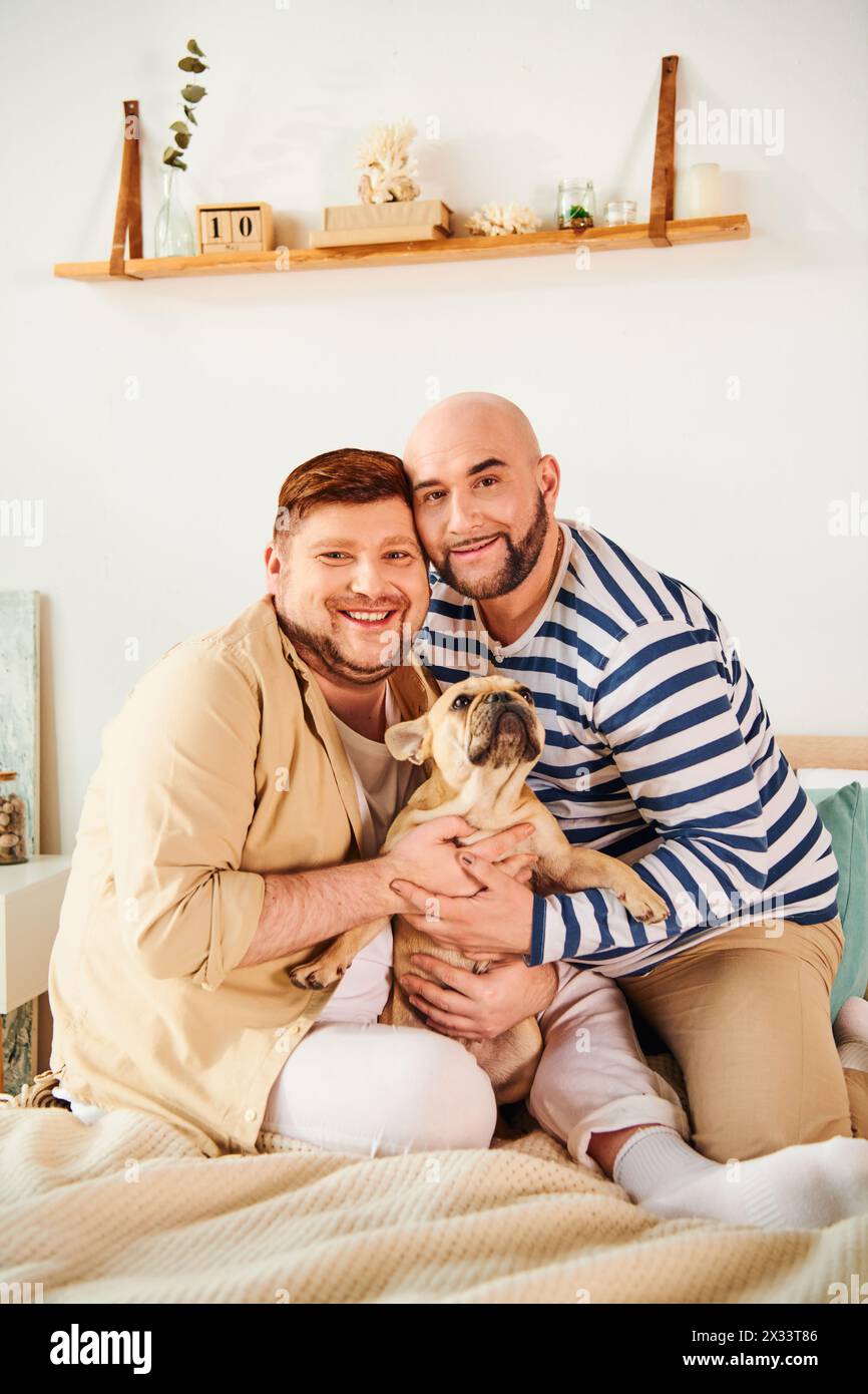 Uomo che tiene in mano il cane mentre seduto sul letto, mostrando tenero amore e affetto. Foto Stock