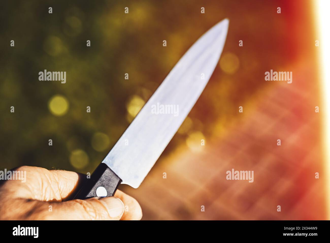 Mano maschile con coltello, attacco simbolico con coltello fotografico Foto Stock