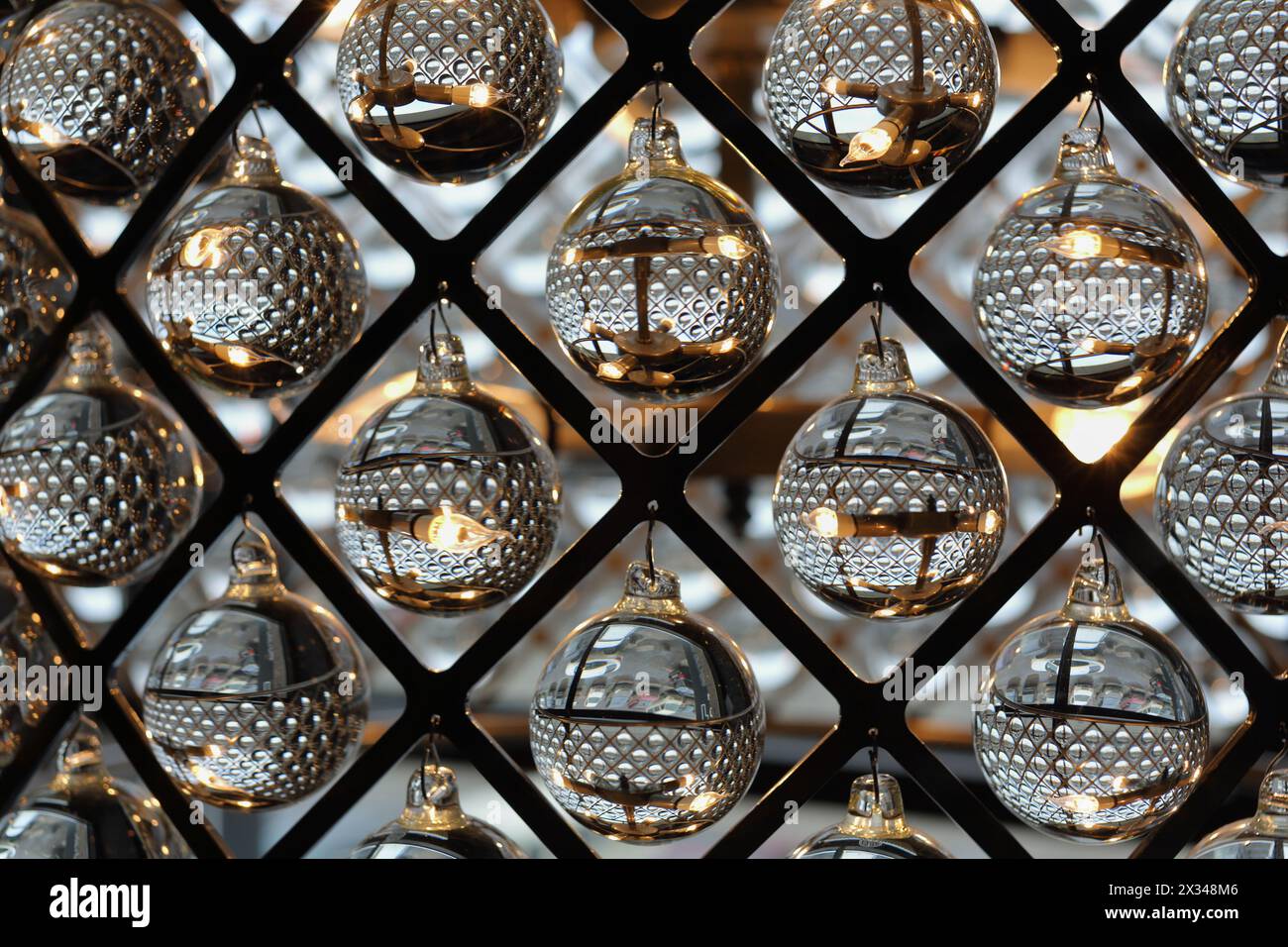 sfere di vetro trasparenti appese in diamanti a reticolo metallico, decorazioni ornamentali Foto Stock