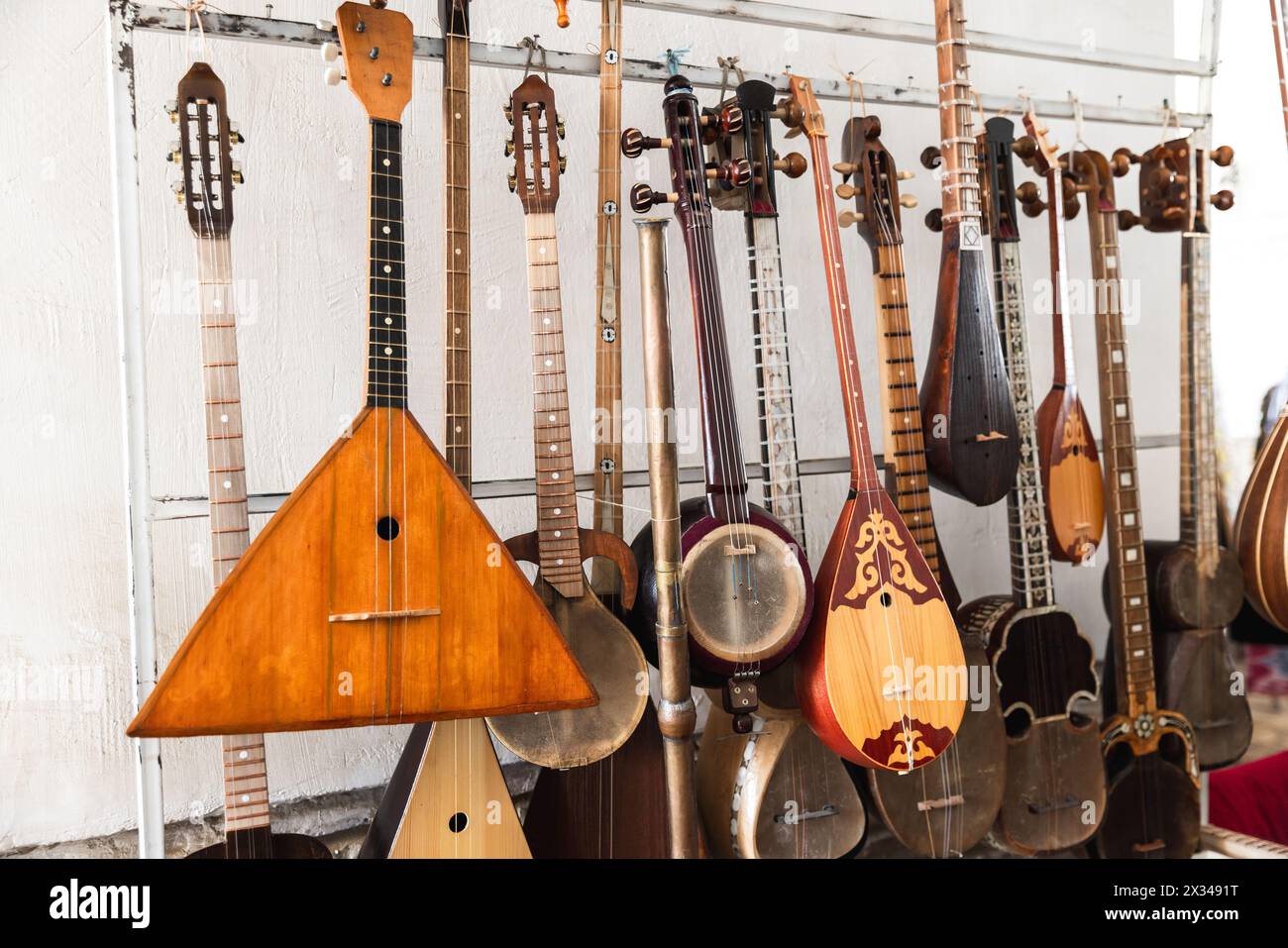 Una varietà di strumenti musicali a corda asiatici sono messi in vendita in un bazar di Bukhara Foto Stock