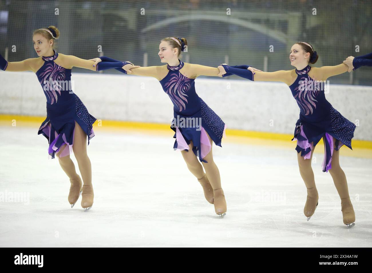 Tre ragazze in splendidi abiti sul ghiaccio al pattinaggio artistico sincronizzato nel complesso sportivo Foto Stock