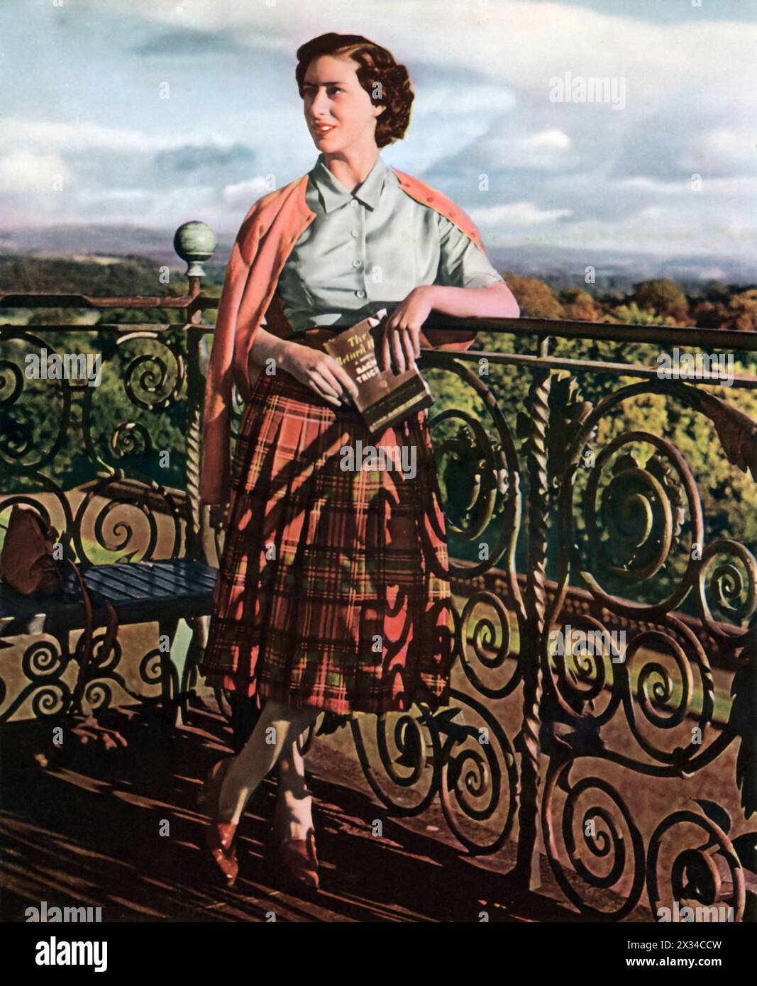 La principessa Margherita, sorella della regina Elisabetta II, viene catturata su un balcone in posa con un libro dopo una sessione di studio. In questa immagine, appare modesta e sofisticata, eppure Margaret sarebbe diventata in seguito nota come un'icona della moda e per aver sfidato le norme reali tradizionali. Foto Stock