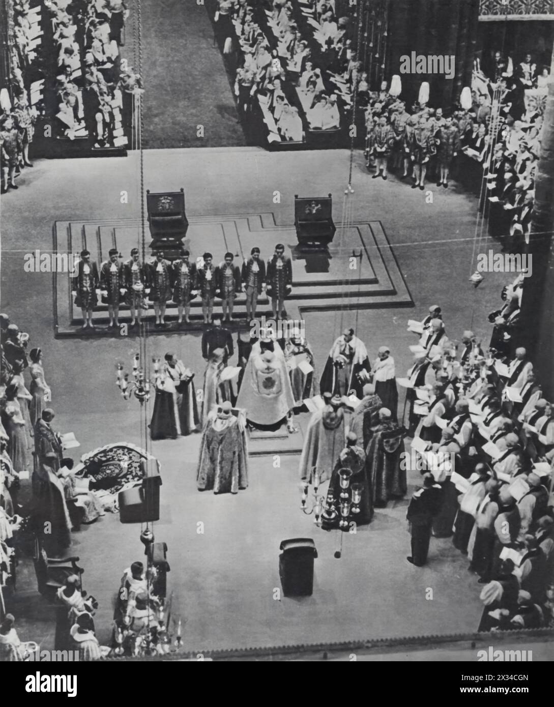 Questa fotografia mostra l'arcivescovo di Canterbury, Cosmo Lang, che pose la corona sulla testa di re Giorgio vi nel maggio 1937, a seguito della crisi dell'abdicazione. Questa crisi si verificò quando il fratello di Giorgio vi, Edoardo VIII, abdicò al trono nel 1936 per sposare Wallis Simpson, un divorziato, portando all'inaspettata ascesa di Giorgio. L'incoronazione simboleggiava non solo un nuovo inizio per la monarchia britannica, ma anche stabilità e continuità dopo un periodo di turbolenze costituzionali senza precedenti. Foto Stock