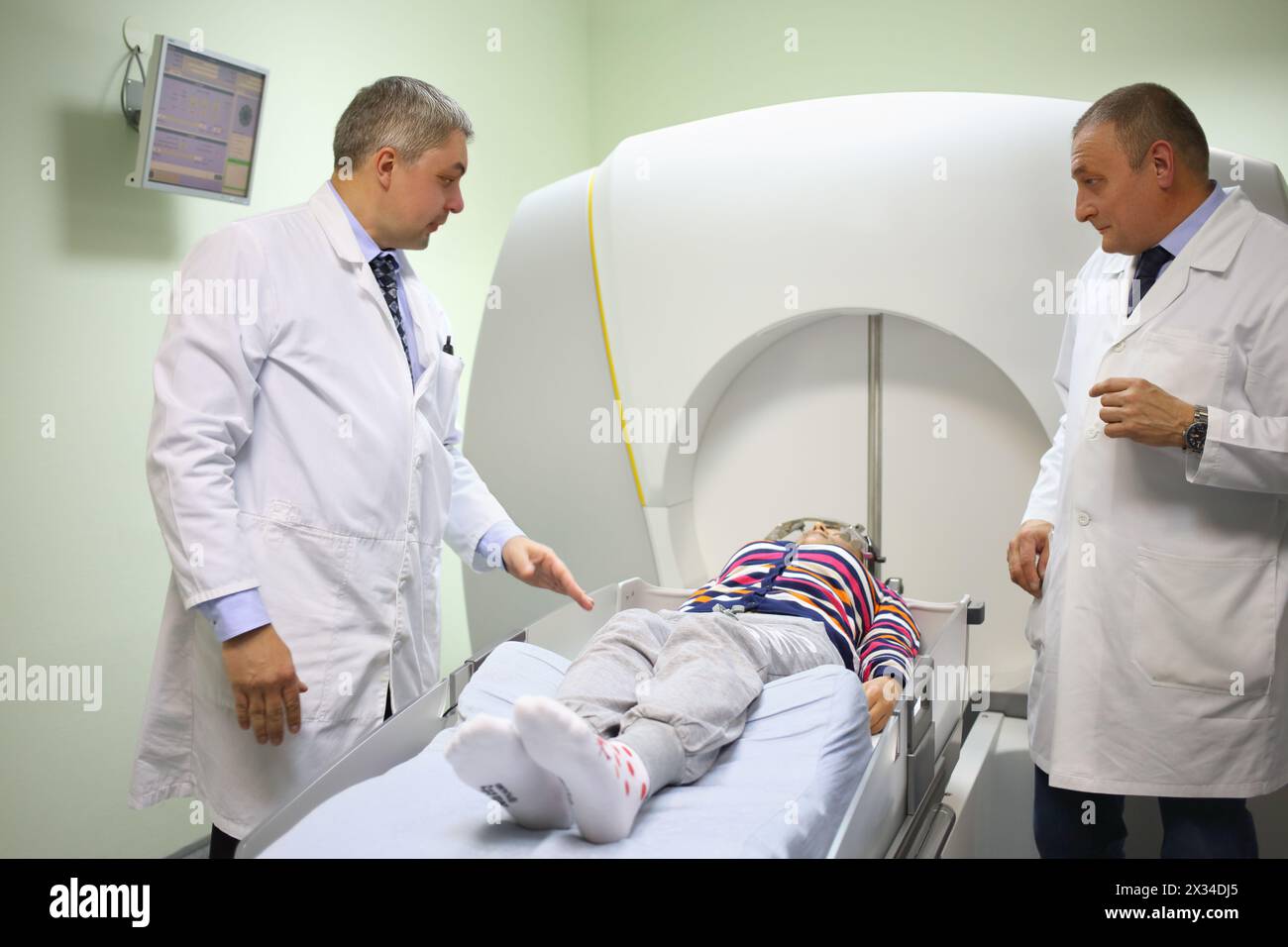 Due medici preparano il paziente all'intervento sul gamma Knife nel reparto di radiologia e radiochirurgia dell'Istituto di Neurochirurgia Foto Stock