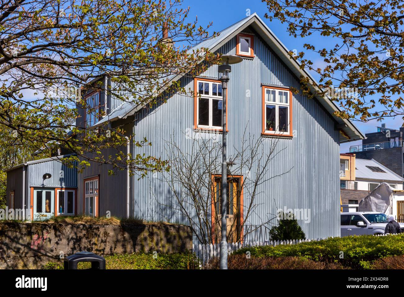 Tradizionale edificio residenziale islandese con tetto a tegole, telai bianchi per finestre, rivestiti in lamiere ondulate a Reykjavik, Islanda. Foto Stock