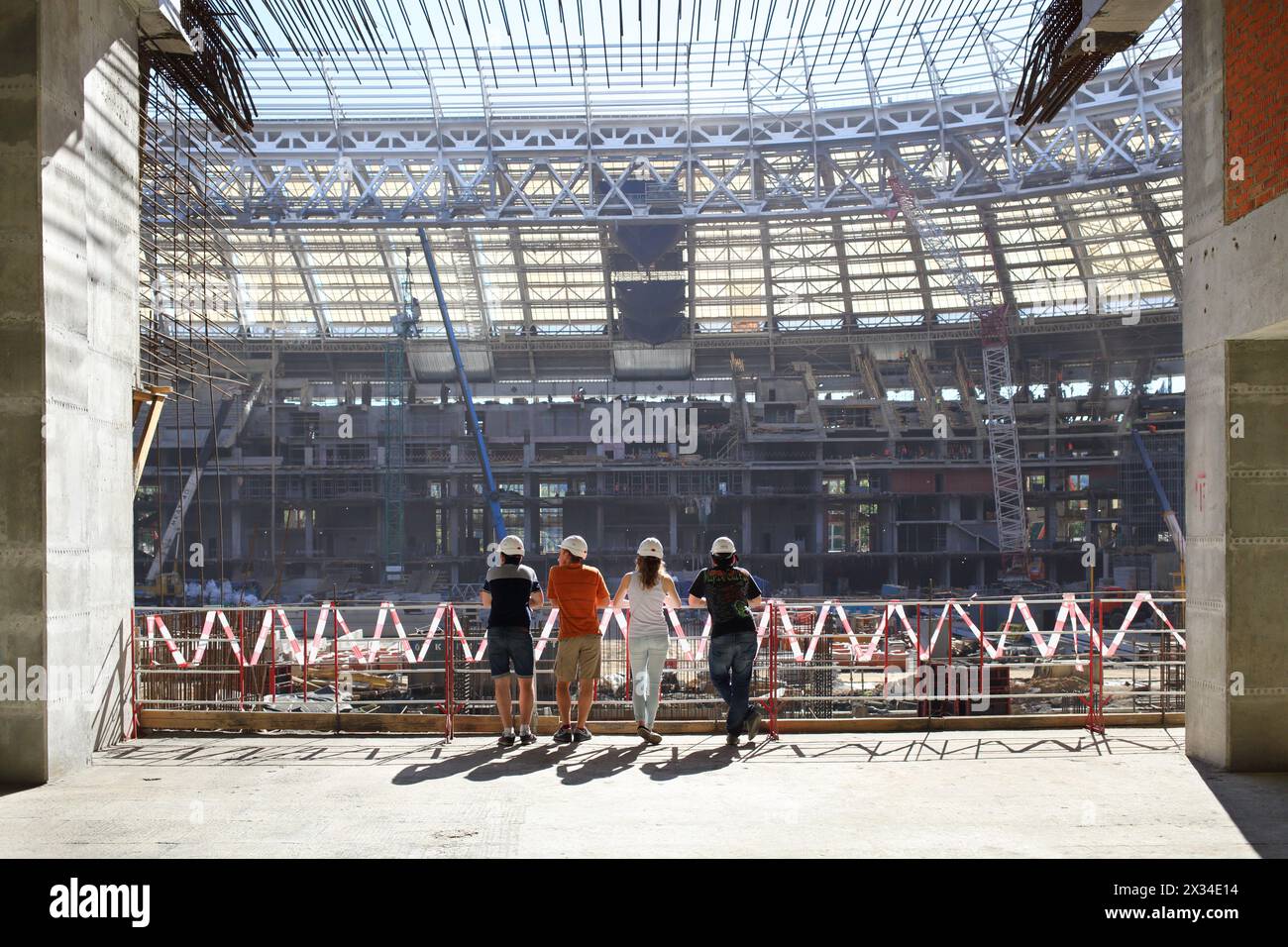 MOSCA - 08 agosto 2015: Giovani in caschi che guardano i lavori di costruzione dello stadio principale Luzhniki, vista dal retro Foto Stock