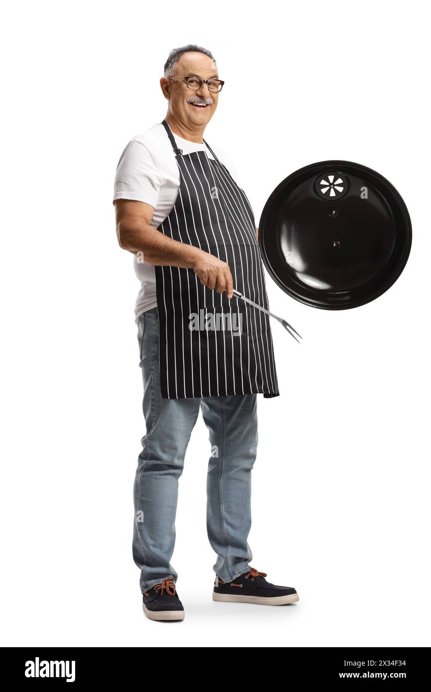 Uomo maturo che tiene in mano una copertura per barbecue e una forchetta isolata su sfondo bianco Foto Stock